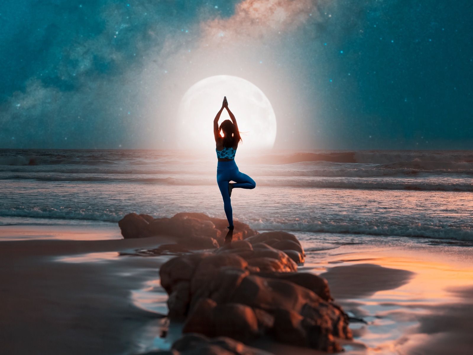 Frau in der Baumhaltung am Meer vor dem Vollmond